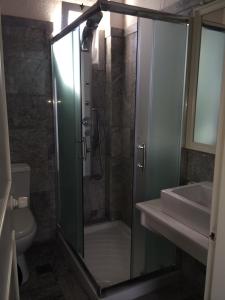 鲁特罗Hotel Porto Loutro on the Hill的一间带玻璃淋浴和水槽的浴室