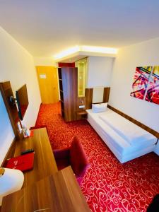 伦廷Hotel Günter的酒店客房,配有床铺和红地毯