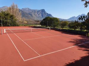 弗朗斯胡克德布伦德尔住宿加早餐旅馆的一座以山脉为背景的网球场