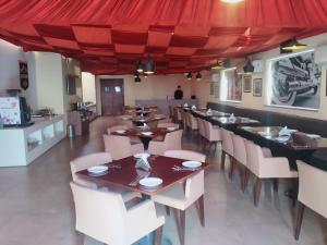 贾姆穆Le Roi Jammu - Near Jammu Railway Station的一间带桌椅和红色天篷的餐厅