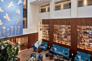 雅典埃雷特拉都市酒店的图书馆,里面摆放着蓝色的沙发和书籍
