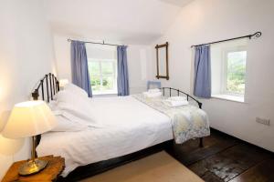 安布尔塞德Pye Howe的卧室配有一张白色大床和两个窗户