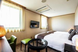 静冈奎斯特清水酒店的一间酒店客房,设有两张床和电视