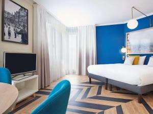 巴黎凡尔赛宫阿德吉奥公寓酒店的一间酒店客房,配有一张床和一台电视