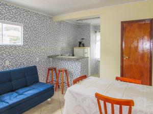 甘博阿Hospedagem do Peduca的客厅配有蓝色的沙发和桌子