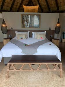 威尔吉旺登禁猎区Laluka Safari Lodge - Welgevonden Game Reserve的一间卧室配有一张大床,内有长凳