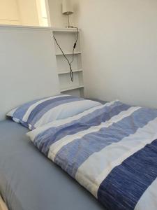 小马赫诺südausgerichtetes Apartment SüdWest Kleinmachnow的床上有蓝色和白色的毯子