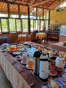 库尼亚Pousada Colar de Ouro的一张长桌,上面有食物和饮料