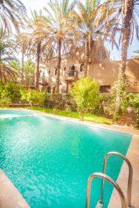 扎古拉7 bedrooms house with shared pool terrace and wifi at Zagora的棕榈树屋前的游泳池