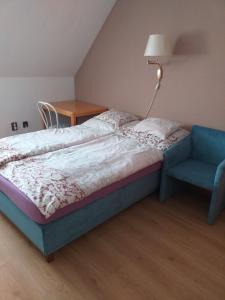 根尼斯迪亚斯Szilvió的一间卧室配有一张床和一张蓝色椅子