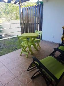 Happy BayOne bedroom appartement with furnished garden and wifi at La Savane 2 km away from the beach的一个带绿色桌椅的庭院
