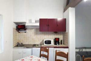 Saint-Martin-au-BoscMaison de 3 chambres avec jardin clos et wifi a Edruchon的厨房配有红色橱柜和桌椅