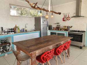 马里卡Casa do Maracuja的厨房配有木桌和红色椅子