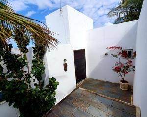马里卡Casa do Maracuja的白色的房子,有门,有植物