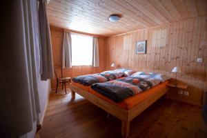 雷金根Alpensonne的木制客房内的一间卧室,配有一张床