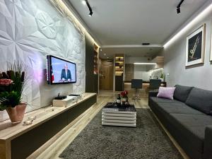 斯维诺乌伊希切4UApart-Apartment suite Platan Grey的客厅配有沙发和墙上的电视