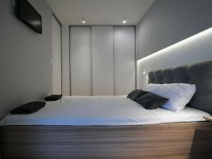 斯维诺乌伊希切4UApart-Apartment suite Picasso的一间卧室配有带白色床单和黑色枕头的床。