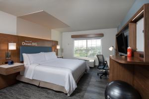 森特尼尔EVEN Hotels Denver Tech Center-Englewood, an IHG Hotel的酒店客房配有一张床、一张书桌和一台电视。