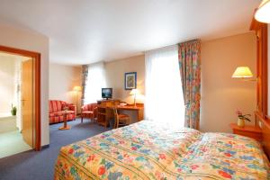 施泰因海姆格鲁伯酒店的配有一张床和一张书桌的酒店客房