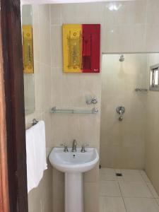 Fajara鹈鹕旅馆的白色的浴室设有水槽和镜子