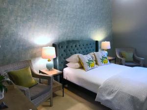波特兰West End Inn的一间卧室配有一张带两把椅子和两盏灯的床。