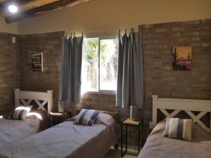 巴雷阿尔Cabañas EL AGUARIBAY的一间卧室设有两张床和窗户。
