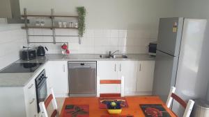 沃加沃加Alkion Villa的厨房配有桌子和冰箱