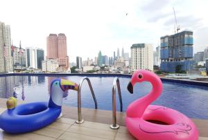 吉隆坡Leo Palace New Wing, WTC Kuala Lumpur的两个塑料天鹅坐在游泳池边