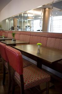 阿伯丁Leonardo Hotel Aberdeen的餐厅的桌椅,桌子和长凳