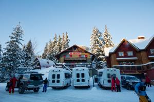 罗斯兰红快门旅馆的一群人站在小屋前的雪中