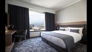贝鲁特Hotel De Ville的配有一张床、一张书桌和一扇窗户的酒店客房