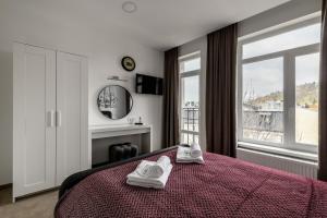 利沃夫City Aparts Kulisha Str的一间卧室配有一张床,上面有两条毛巾