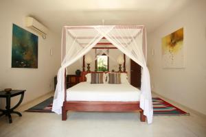 肯克拉科加拉海之星度假屋的一间卧室配有一张带天蓬的床