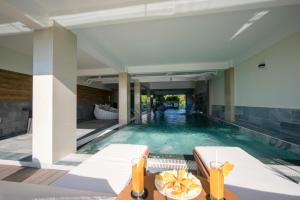 富国UM-PQ hotel Phú Quốc的房屋内带桌椅的游泳池