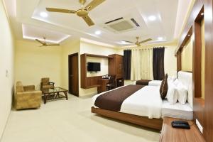 阿姆利则Hotel Amritsar International的配有一张床和一把椅子的酒店客房