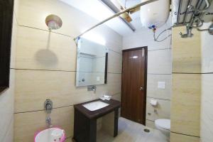 阿姆利则Hotel Amritsar International的一间带水槽、卫生间和镜子的浴室