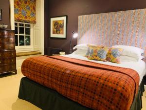 泰特伯里克劳斯酒店的一间卧室配有一张带橙色毯子的大床