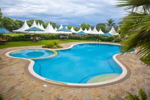 纳库鲁Royal Green Gardens Resort的度假村的游泳池,带遮阳伞