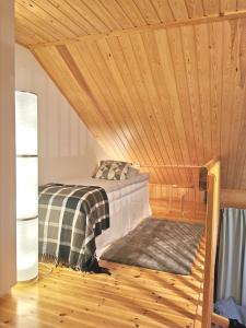 萨利色尔卡Gold Legend Paukkula #1 - Saariselkä Apartments的木天花板的客房内的一张床位