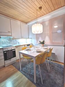 萨利色尔卡Gold Legend Paukkula #1 - Saariselkä Apartments的厨房配有白色的桌子和黄色的椅子