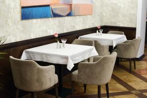 斯特雷Zoloto Karpat的用餐室配有2张桌子和椅子,并鲜花盛开