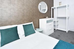EtruriaTownhouse PLUS @ Lower Beth Street Stoke的卧室配有白色的床和镜子