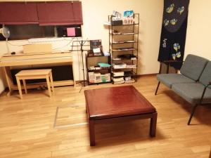 岐阜ゲストハウス山本的客厅配有沙发、桌子和钢琴
