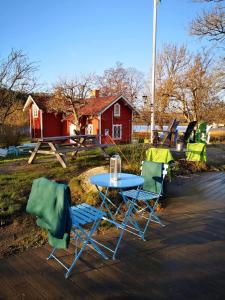 TyresöNotholmen, Tyresö的蓝色桌子和两把椅子,红色房子