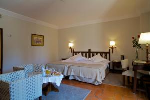 阿维拉帕拉多阿维拉酒店的酒店客房带一张床、一张桌子和椅子