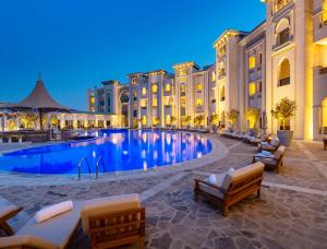 多哈Ezdan Palace Hotel的大楼前设有大型游泳池的酒店