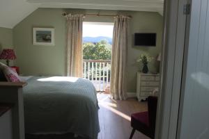 米德赫斯特The Green Room的一间卧室设有一张床和一个阳台的窗户。