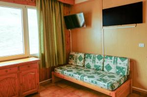 帕斯底拉卡萨Kione Sapporo的客厅配有沙发和墙上的电视