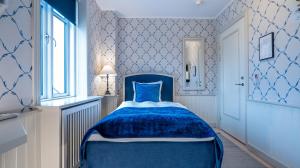 霍恩拜克布列塔格尼酒店的蓝色的卧室设有蓝色的床和窗户