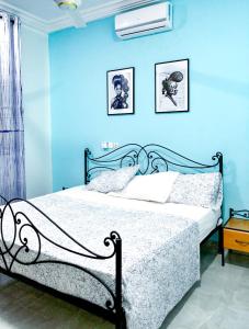 博博迪乌拉Villa Soudan的一间卧室配有一张蓝色墙壁的床